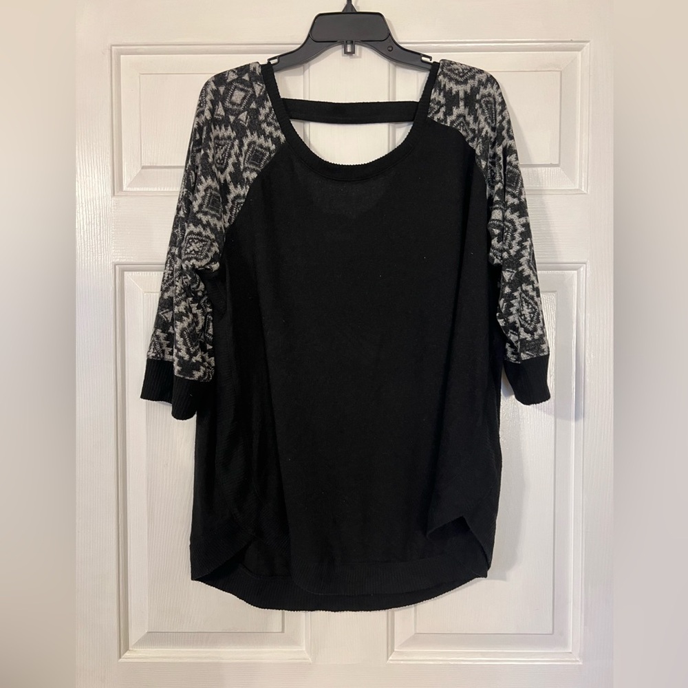 Black top with 3/4 length Aztec print sleeves and bar back detailing.